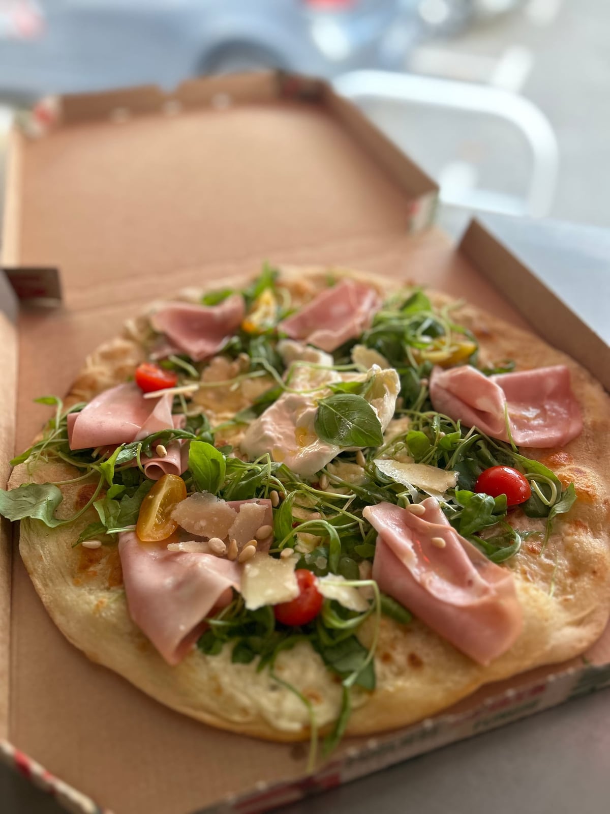 Pizza jambon, burrata, roquette et pignons de pin